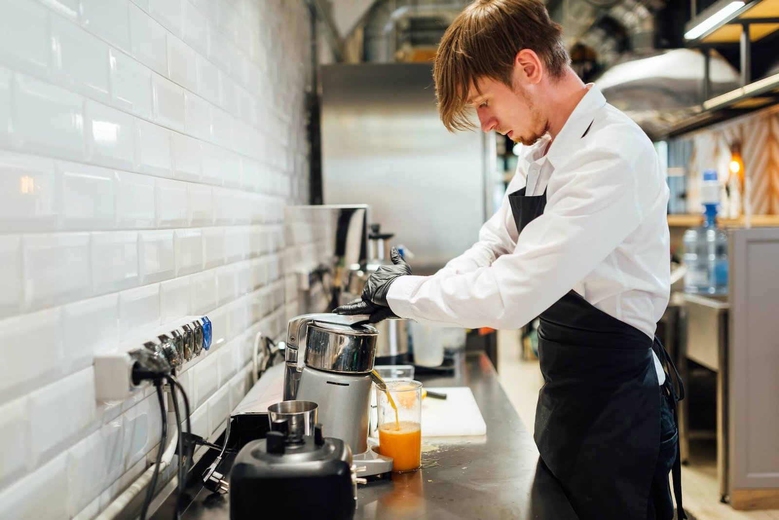 a-cafe-worker-makes-orange-juice-in-a-juicer-catering-kitchen-work-.jpg