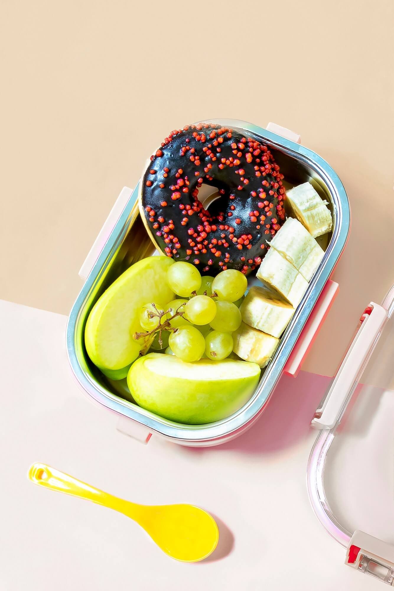 catering-food-prepared-in-storage-container-with-compartment-with-doughnut-apple-banana-grape.jpg